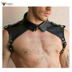 Man wearing a black leather shoulder harness against a neutral background