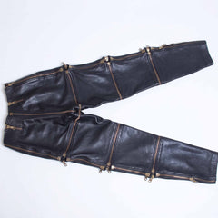 Flat lay view of handmade black leather convertible pants showing all horizontal and vertical zip off sections fully spread