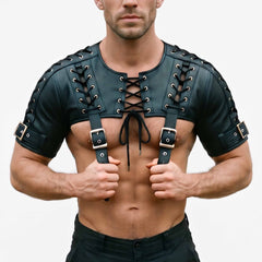 Front view of athletic man holding buckle straps of handmade black cowhide leather bolero harness crop top with chest cord lacing