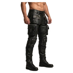 A man wearing black leather cargo pants with multiple flap pockets and black leather knee-high boots, shown from the chest down against a plain beige studio background. A Leather Mania logo is visible in the top-left corner.