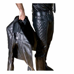 Side angle showing black leather saddle pants paired with a matching leather jacket, highlighting the quilted side panels and vintage belt hardware.