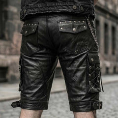 Back view of mens black leather cargo biker shorts showing studded rear flap pockets, side cord lacing, and wallet chain accessory