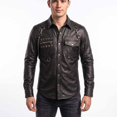 Full front view of handsome young man wearing handmade black sheepskin leather shirt with silver studs, shoulder chains, and snap button placket