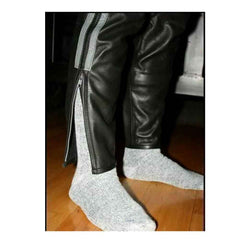 Close-up view of the lower leg showing the unzipped YKK ankle cuff detail on men's leather breeches over socks.