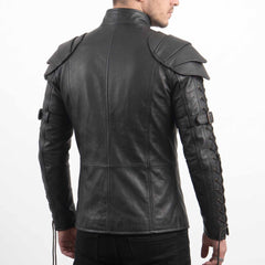 Rear three-quarter perspective of male model modeling black genuine cowhide leather armor top detailing bicep buckle straps and sleeve cord lacing