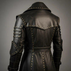 Detailed rear close up of black leather duster highlighting tiered shoulder armor plates, studded saddle capelet, and brass rivet accents