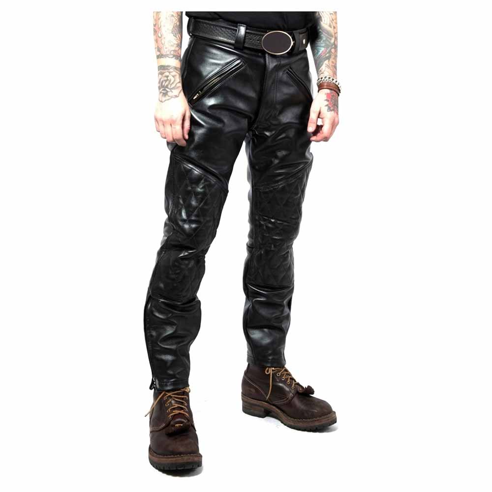 Front view of men's black leather biker jeans displaying angled brass zipper pockets, belt loops, and diamond-quilted knee panels.