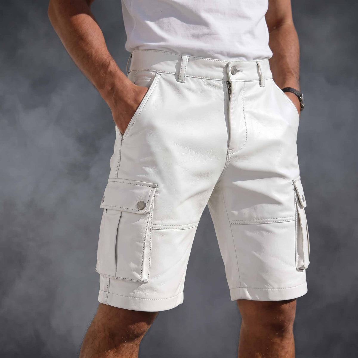 Front three-quarter view of man wearing handmade white cowhide leather cargo shorts with side snap flap pockets and white t-shirt