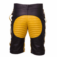 Back view of men's contrast leather clubwear shorts showing yellow padded seat panel, belt loops, and side steel D-ring leg attachments.