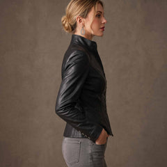 Side profile shot of woman wearing fitted black leather peplum blazer highlighting slim tailored sleeves and waist taper