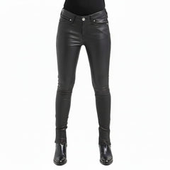 Black leather skinny pants shown on a model from the waist down, paired with a black top and black leather ankle boots, against a plain white background.