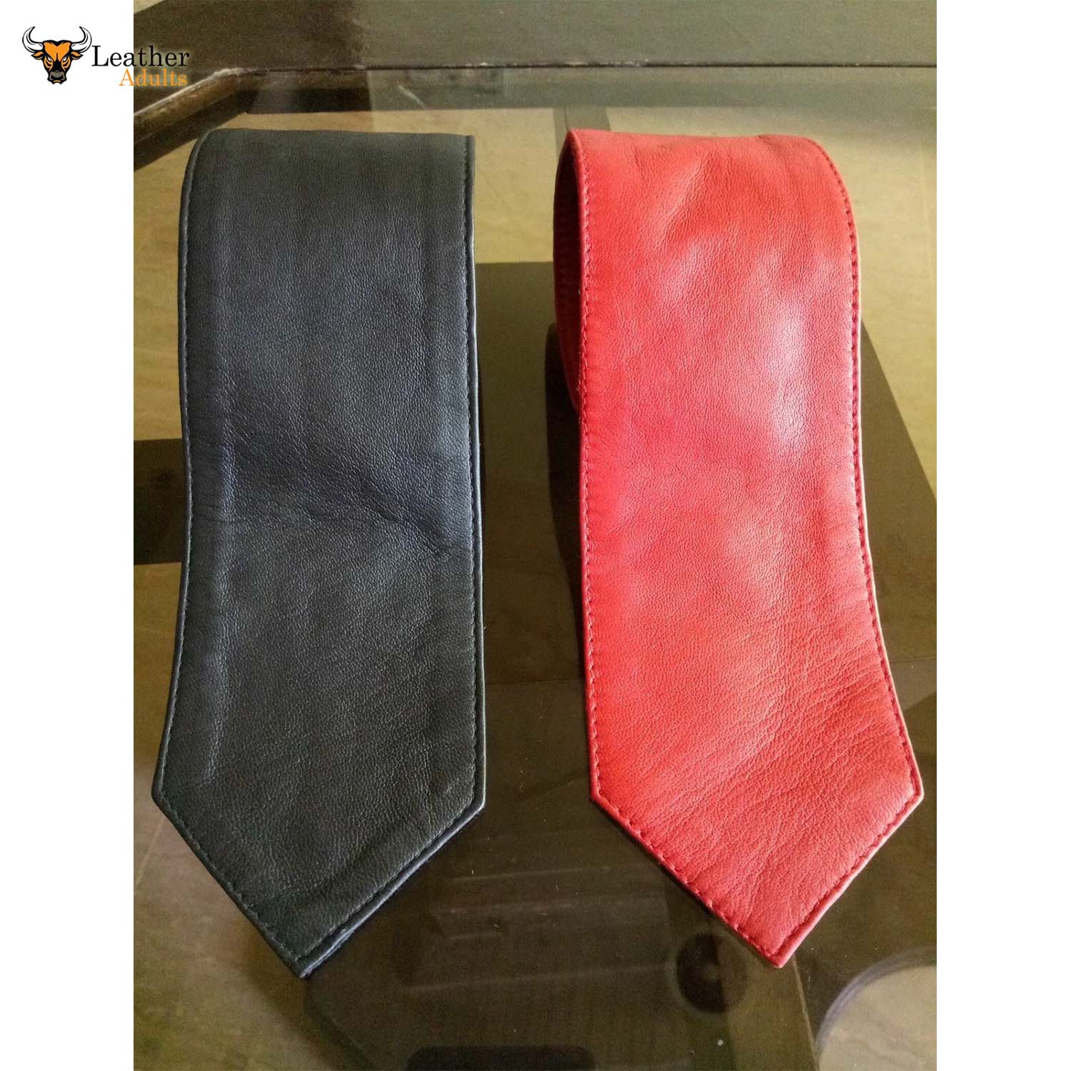 Two men's ties, one in black and the other in red, made of genuine sheepskin leather, displayed on a glass surface.